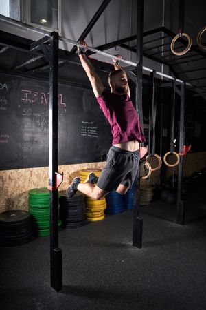 Sportsman doing pull ups in gym