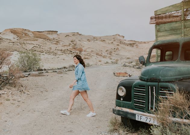 Relaxed female walking by old truck