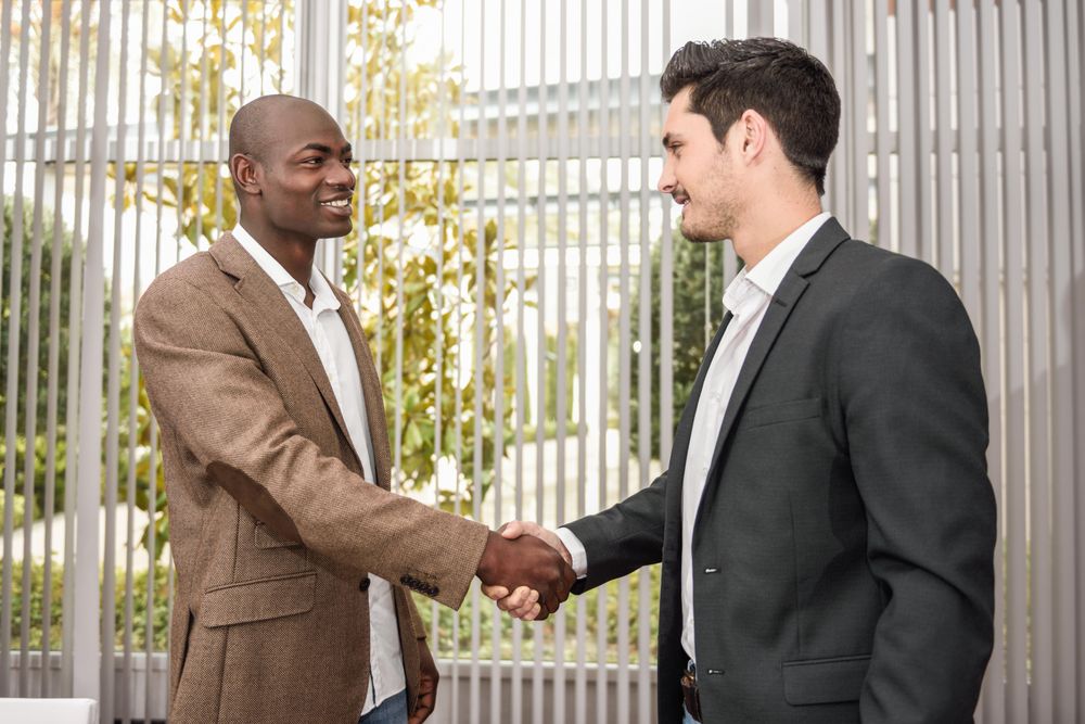 Two men smiling as they shake hands