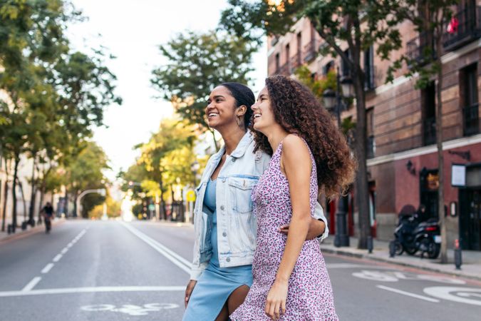 Lesbian couple walking down the street, holding hands.