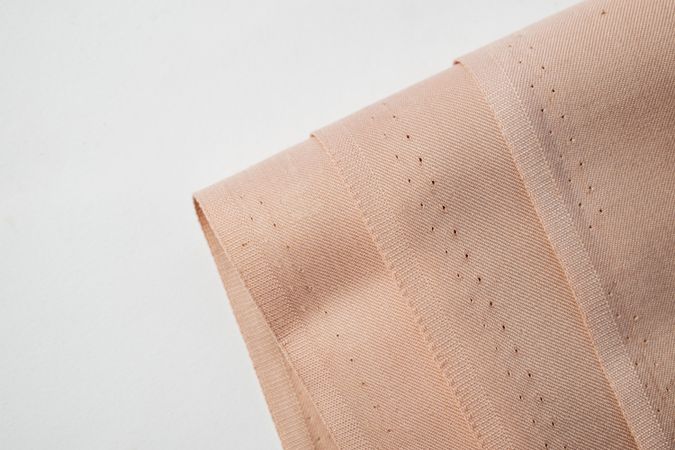 Multi folded light brown fabric background texture.