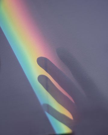 Rainbow and hand shadow on wall