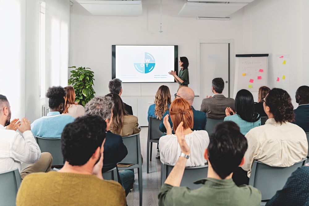 Businesswoman presenting SWOT analysis on large screen in spacious office room