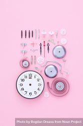 Neatly disassembled clock on pink background 5ogN85