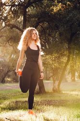 Sportive woman standing on meadow in sunlight