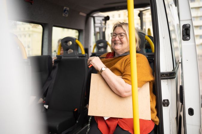 Woman sitting in bus with art supplies
