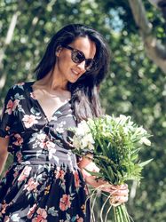 Charming woman with white flowers in park