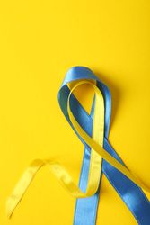Vertical composition of ribbon in Ukrainian flag colors on yellow background