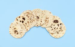 Naan bread pile on a blue table, top view