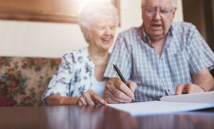 Portrait of a older couple signing documents