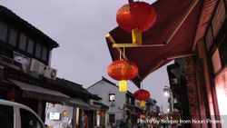 Red Chinese lanterns hung around an awning bxrmj5