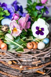 Close up of Easter table setting with centerpiece of giant nest and flowers