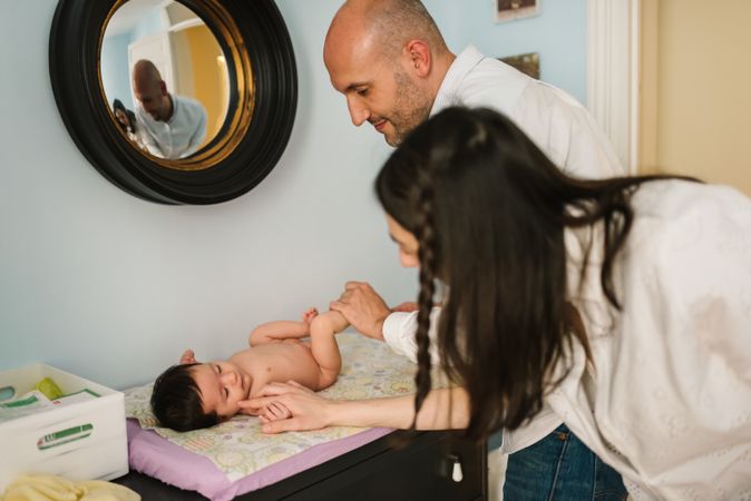Parents changing diaper for baby