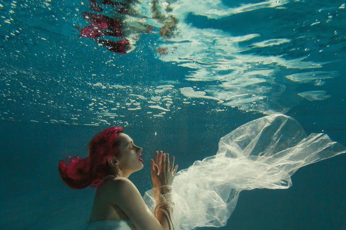 Underwater shot of woman wearing wedding gown