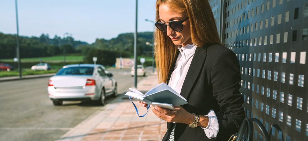 Businesswoman reading diary outdoors