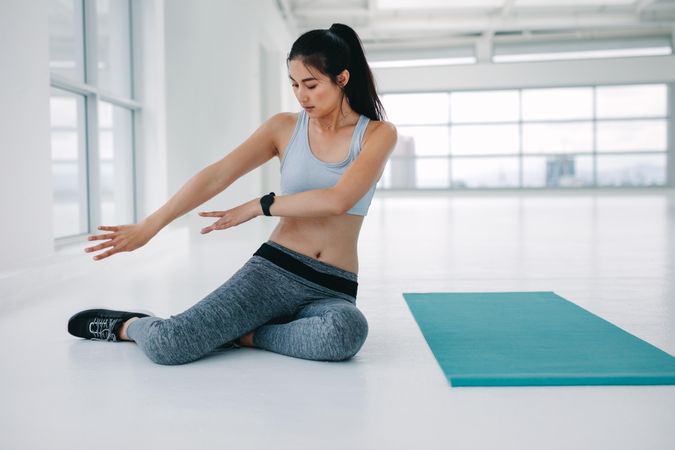 Woman practicing yoga moves before the workout session at fitness studio