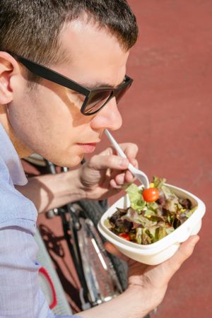 Young business man eating at lunch break outdoors