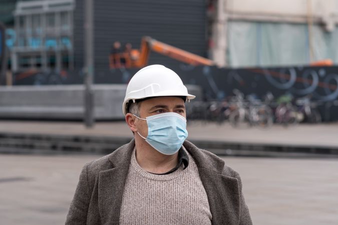 Man with helmet and facemask standing on street
