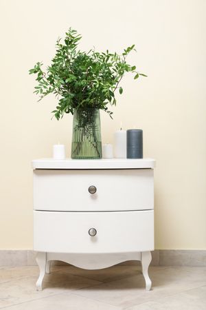 Nightstand with vase with plant and candles