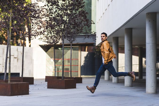 Stylish guy jumping on street