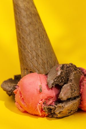 Ice cream cone dropped on yellow background