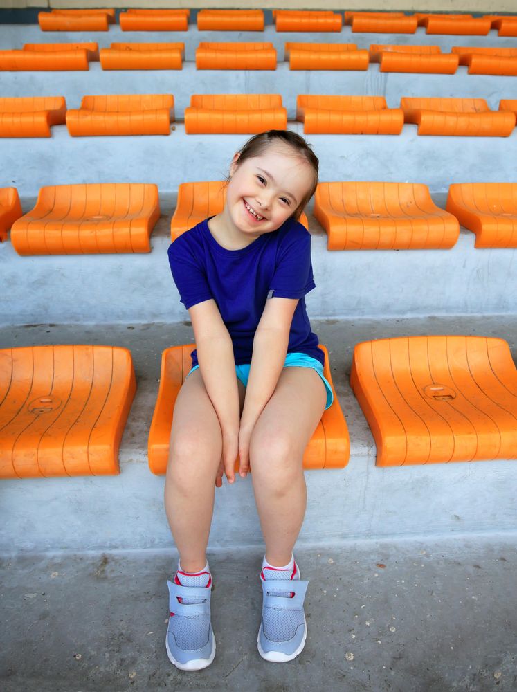 Happy young girl sitting in stadium stand