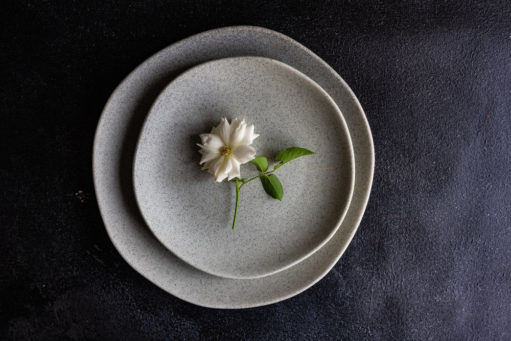 Minimalistic table setting with rose on grey plate