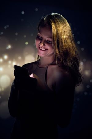 Cheerful woman checking messages on cellphone