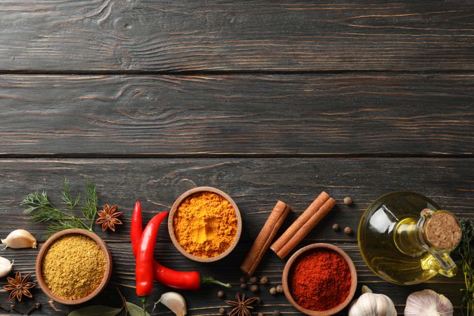 Wooden table scattered with spices and ingredients for cooking