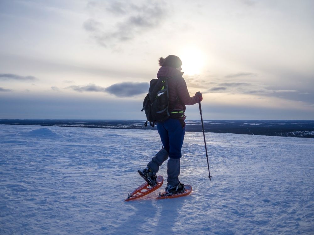 Person snowshoeing in the snow in late afternoon