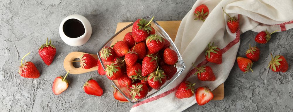 Composition with bowl of tasty strawberry on gray table. Summer berry