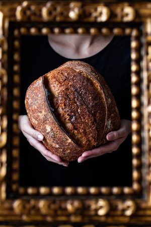 Crop person holding some bread