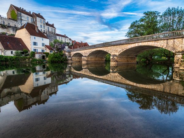 The medieval walled city of Pesmes in Burgundy. Reflection in the river at sunset.
