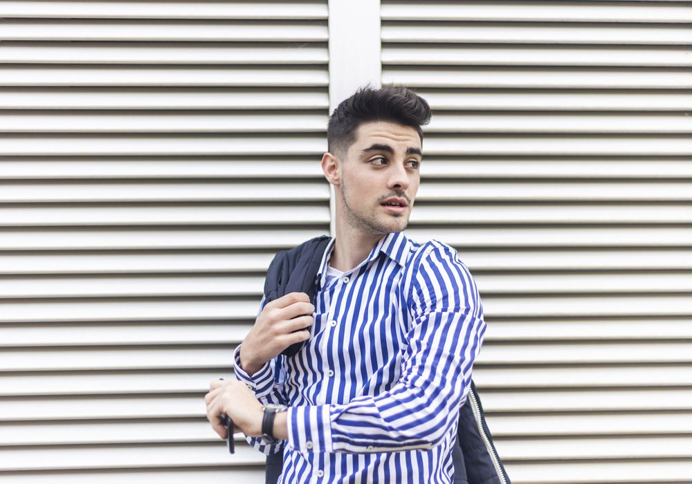 Young man standing outdoors and looking around