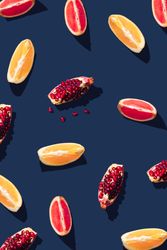 Pattern of grapefruit, orange, pomegranate and lemon slices on navy background