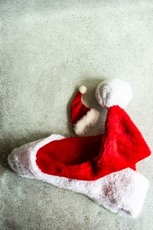 Christmas card concept of santa hats on concrete