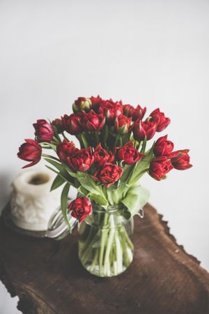Vase of red tulips on wooden table