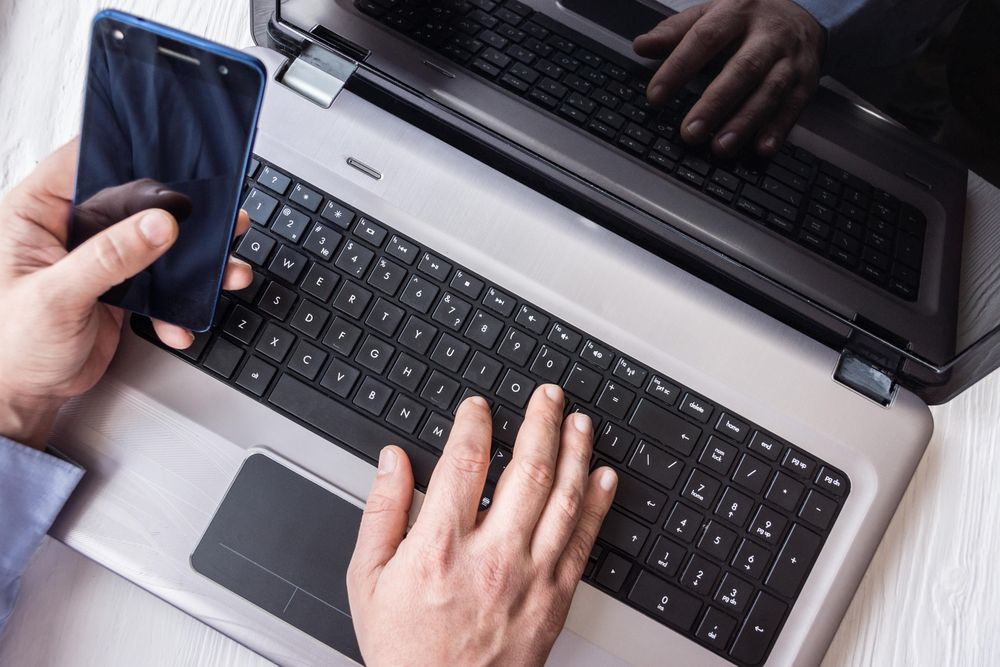 Man using smartphone and laptop