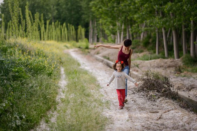 Woman and girl walking on trail in forest