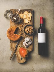 Cheese plate with red bottle of wine