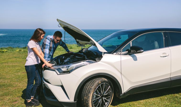 Young couple tries to fix the broken down car