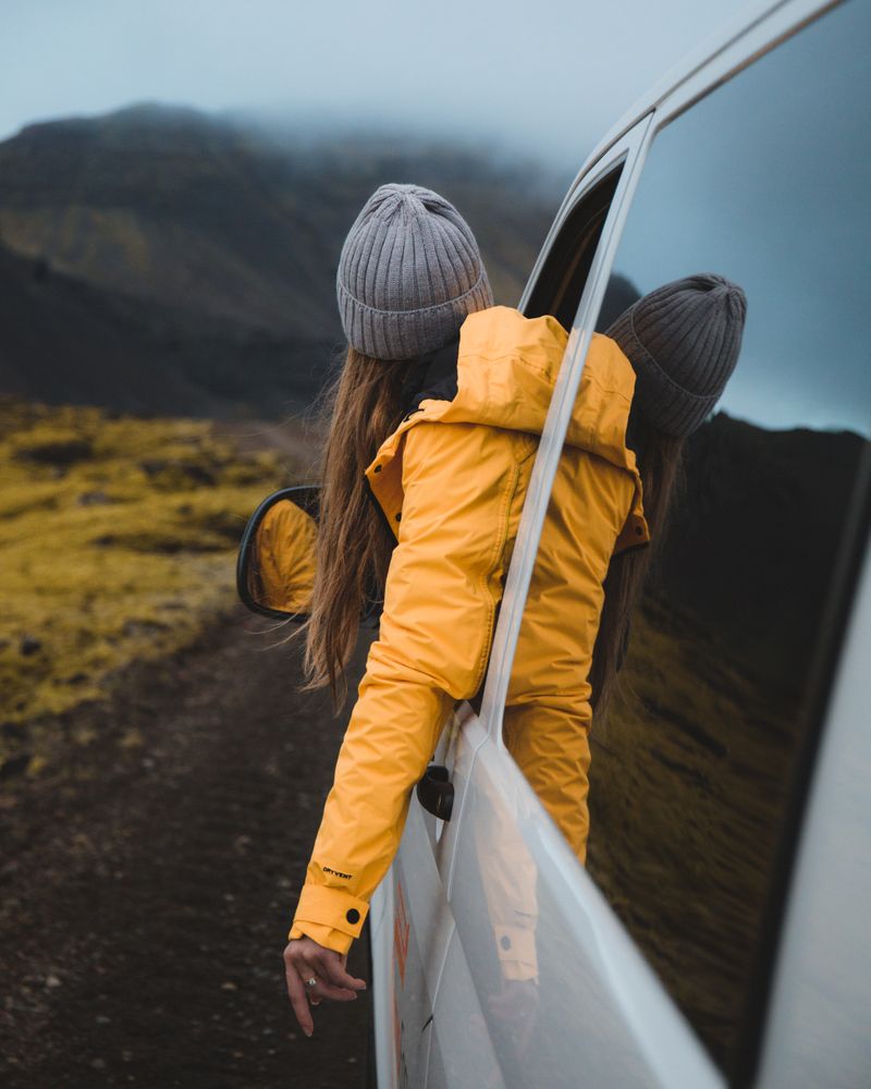 Woman in yellow jacket in the car on the road