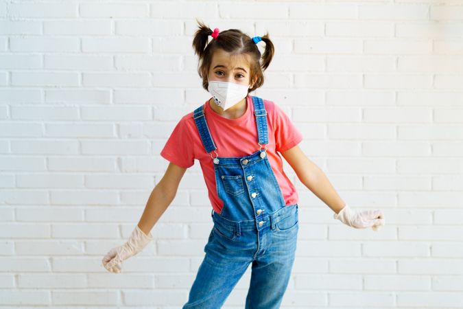 Cute girl in overalls, gloves and facemask