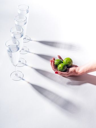 Composition of a hand with citrus and glasses of water