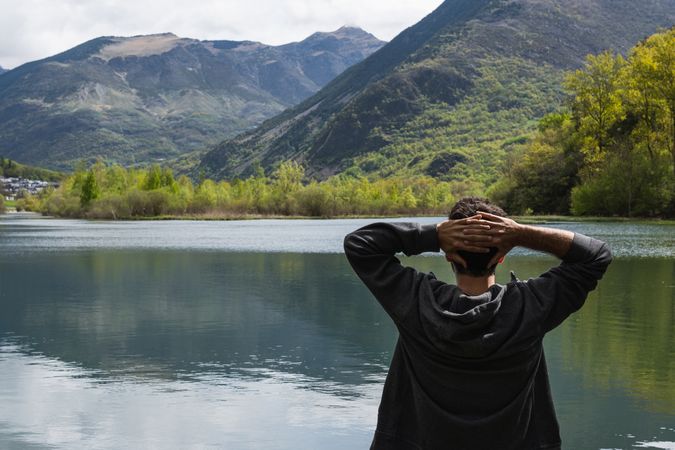 Carefree traveling man enjoying freedom near lake in mountains