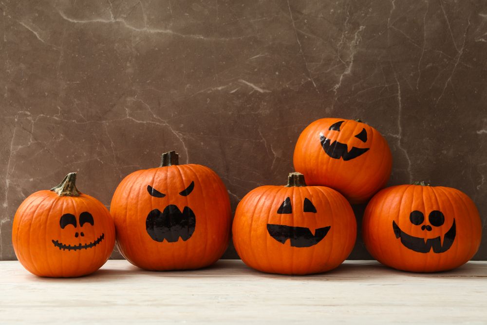 Funny halloween pumpkins against gray background, space for text