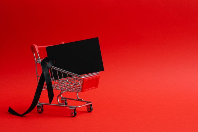 Shop trolley with tag on red background