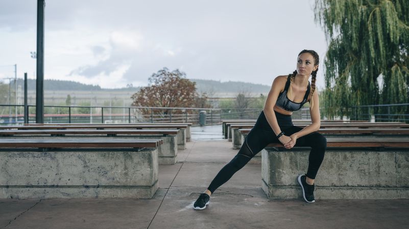 Sportswoman posing sitting on a bench