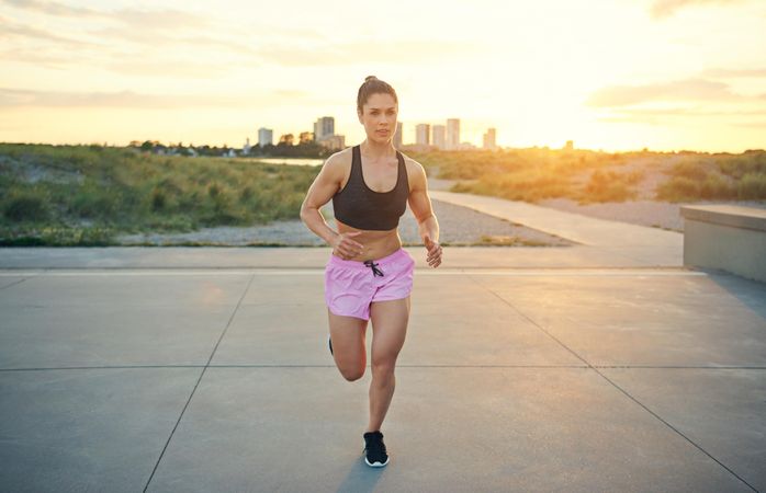 Fit woman running towards camera with skyline in background