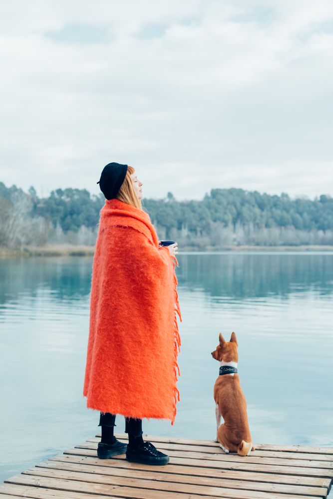 Woman calmly standing on pier with dog
